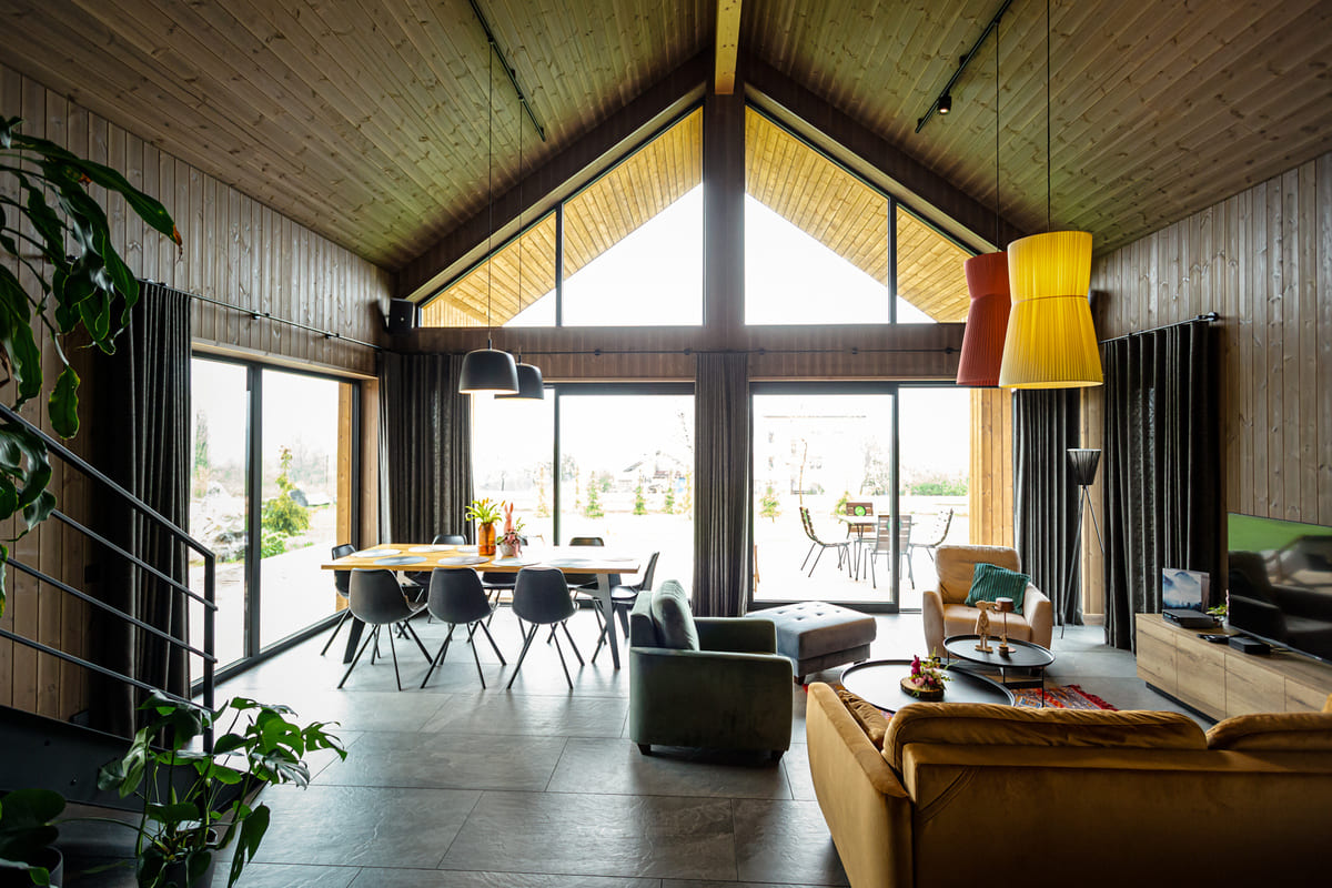 Przestronny salon z dużymi oknami, drewnianym sufitem i nowoczesnym wystrojem – Istebna noclegi.